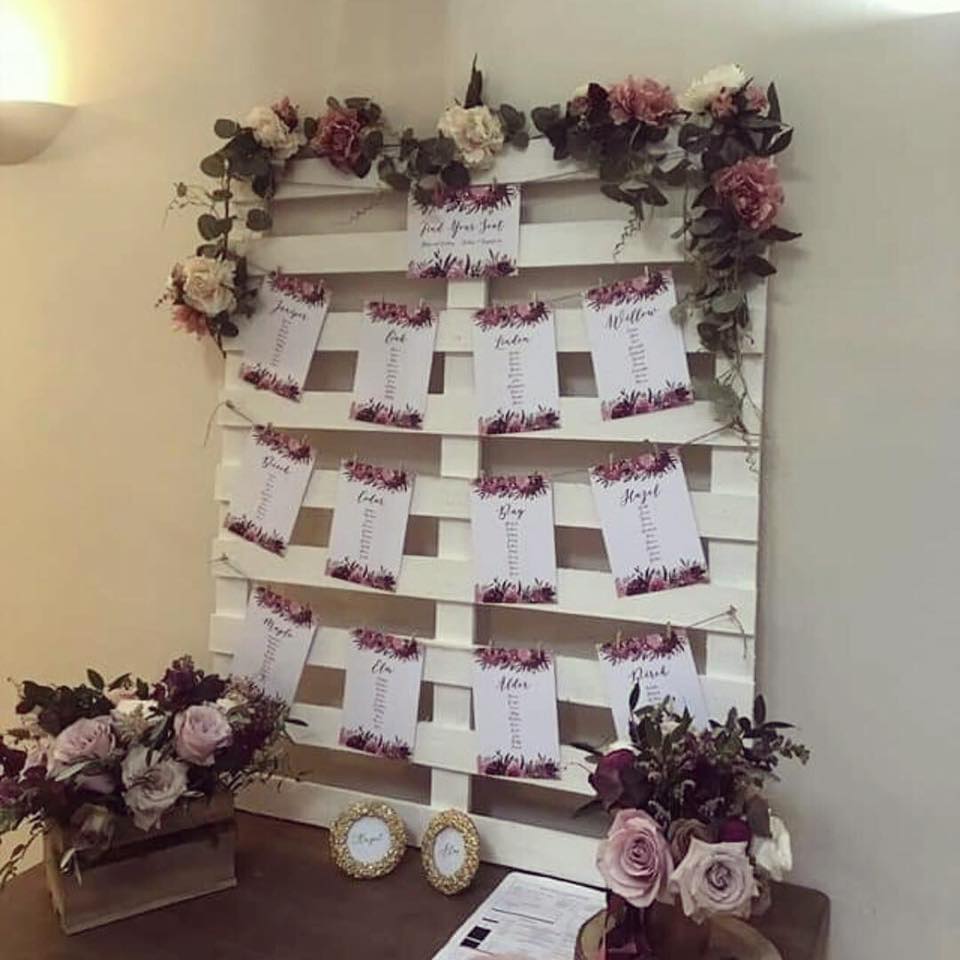 Individual table plan cards presented on a wooden pallet